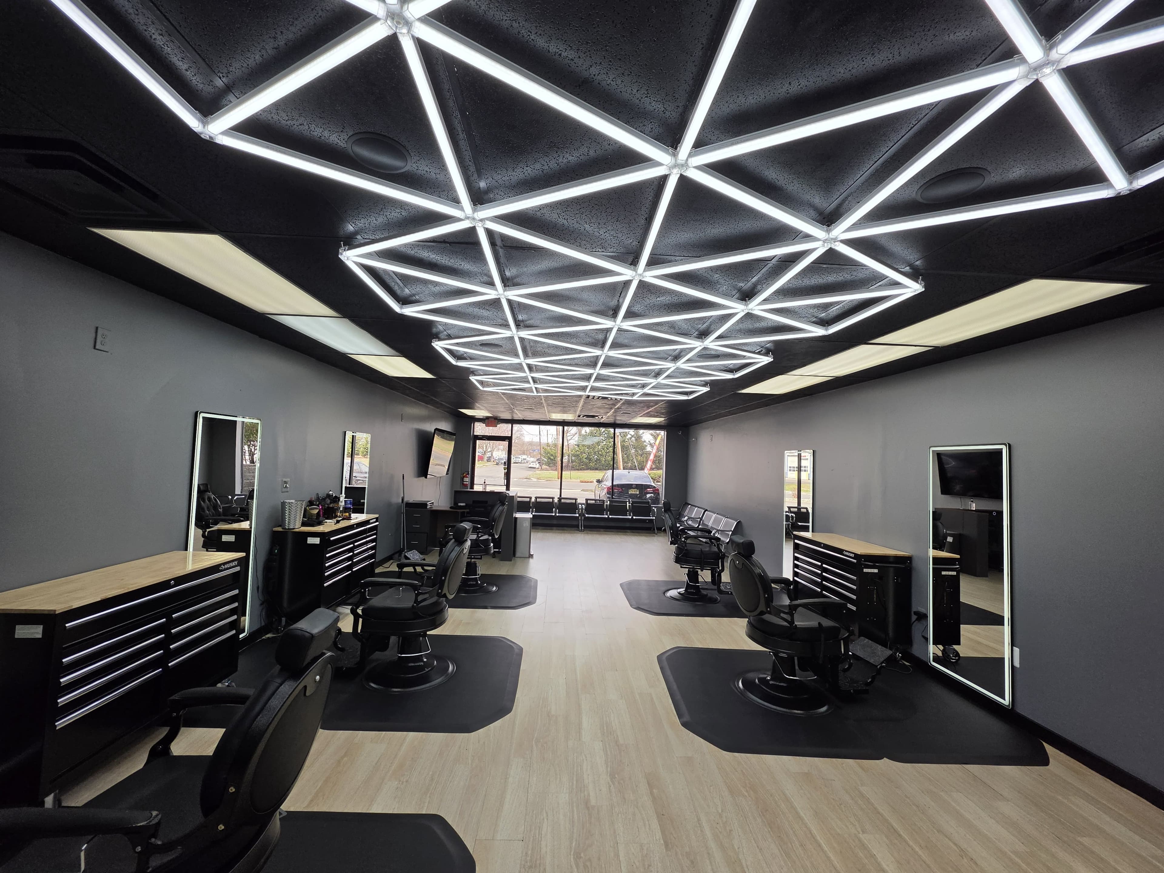 Row of barber chairs and mirrors inside Legacy Studio Barbershop