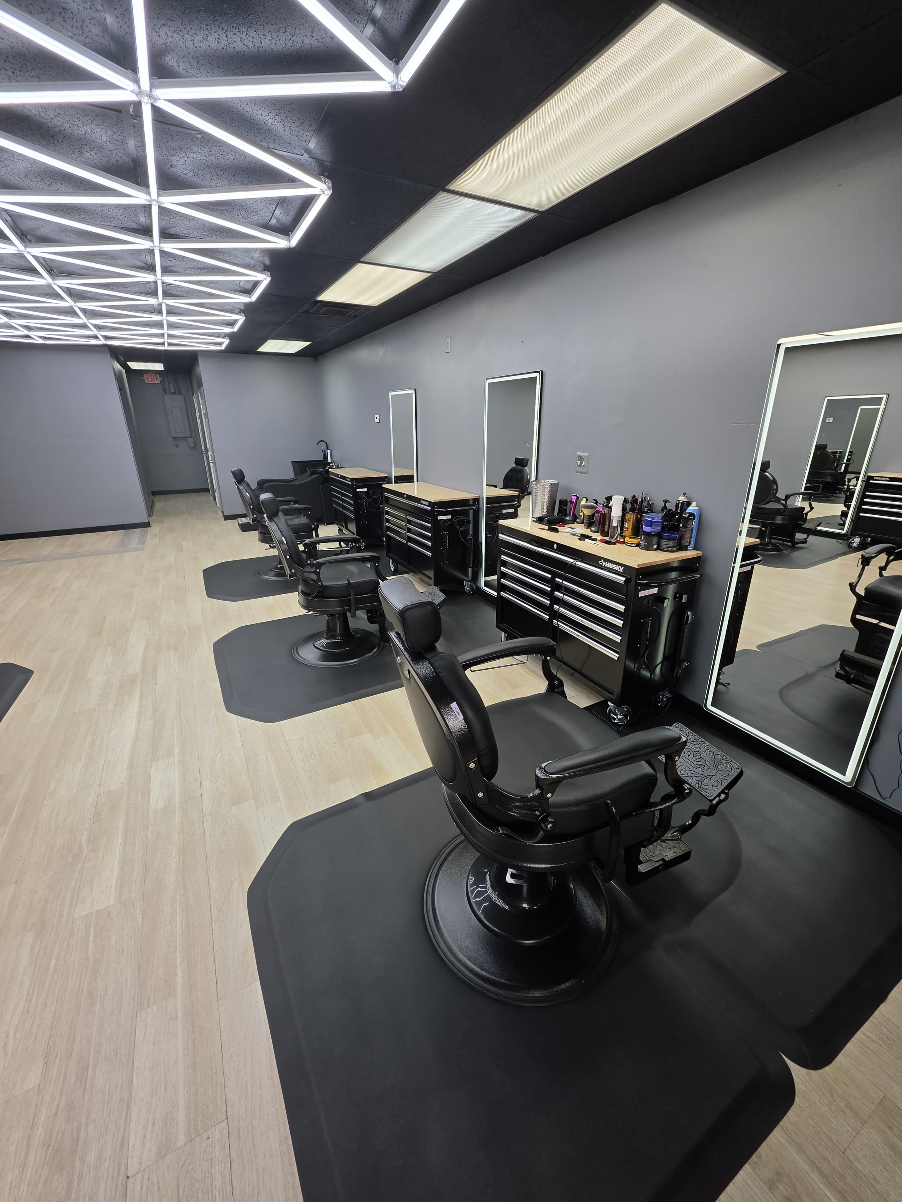 Barber station with a rolling tool chest, styling products, and a chair in the foreground